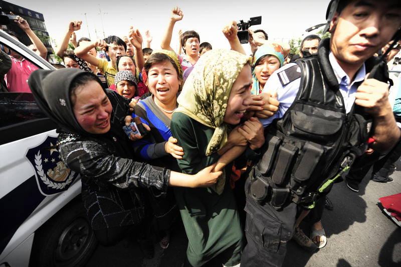 Ethnic Uygur women grab a riot policemen