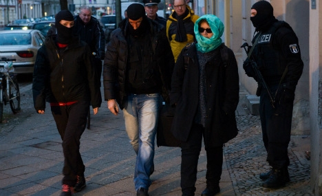 A special operations commander takes the arrested man to a waiting vehicle in Berlin