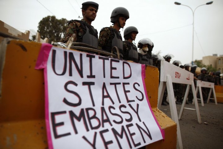 Riot policemen stand guard during a protest to demand the release of Yemeni detainees in the prison of Guantanamo Bay, outside the U.S. embassy in Sanaa