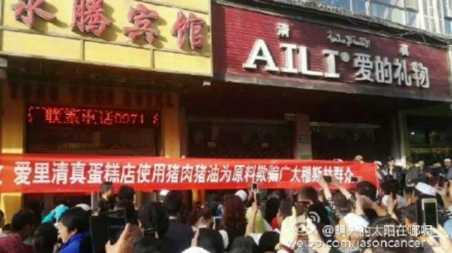 The banner reads, "Ai Li" Muslim cake shop use pork and lard as raw materials to cheat Muslim people."
