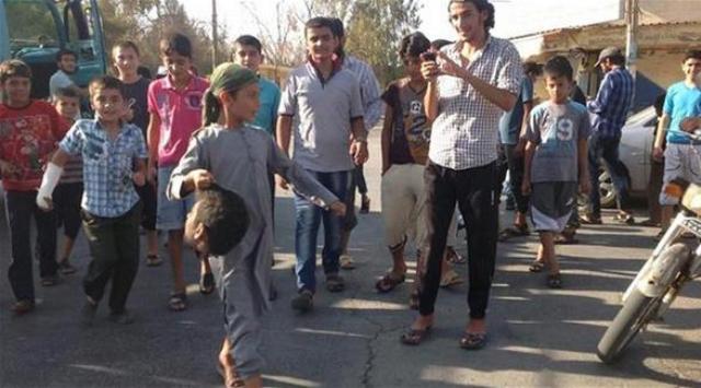The young boy carrying the severed head in Syria seems to be about 12 years old